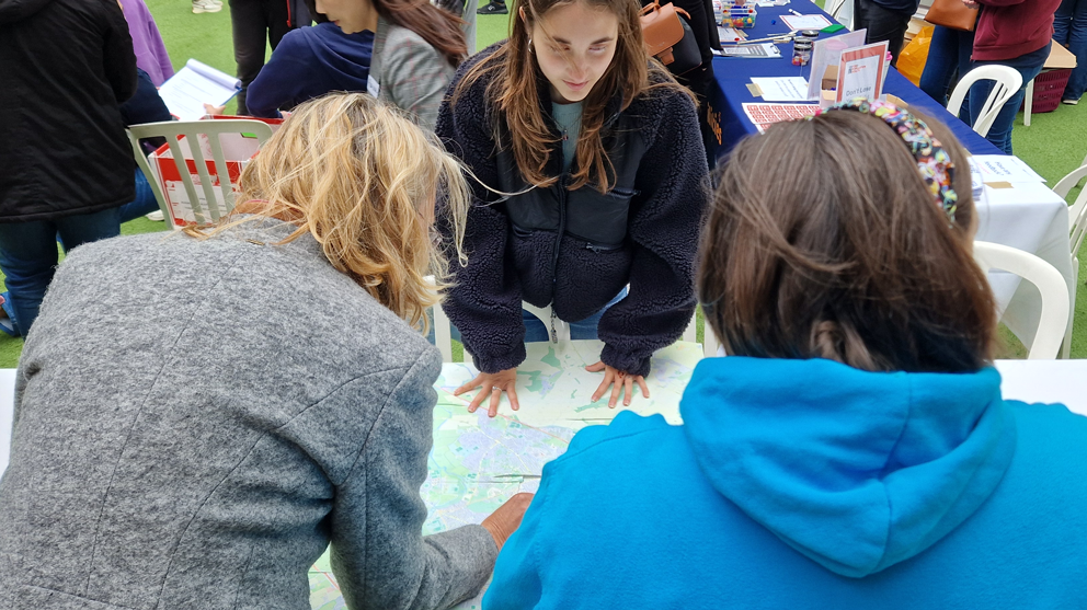 Image of a YPAG member with two visitors looking at a map of green areas in Oxford during the BRC's Open Day 2024
