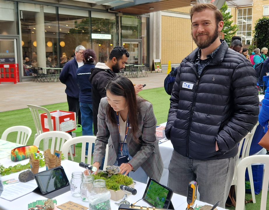 Image of two Flourishing & Wellbeing researchers on their stand during BRC's Open Day 2024